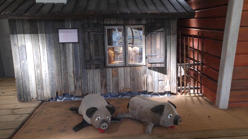 Kaksi pehmopossua vanhan talon edessä Lasten kaupunki-näyttelyssä.