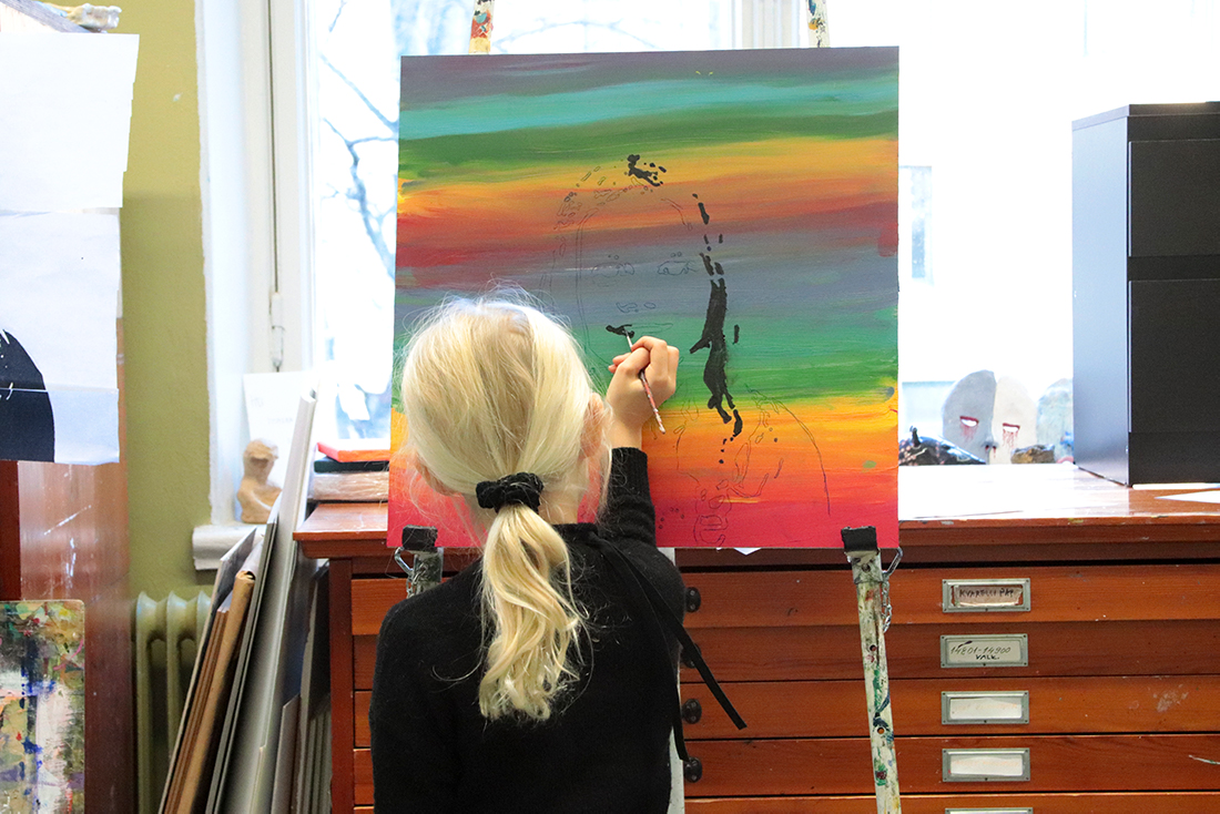 Tyttö maalaa taulua.