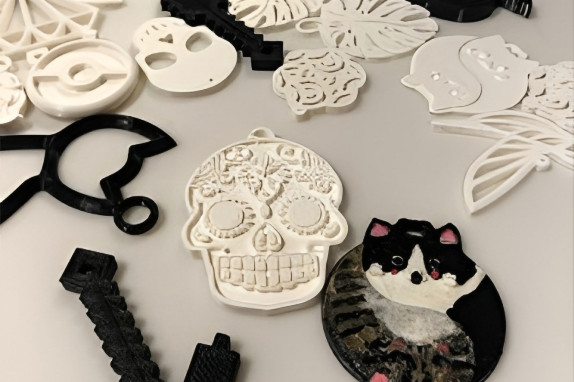 3D-tulostettu korupääkallo ja kissakoru pöydällä