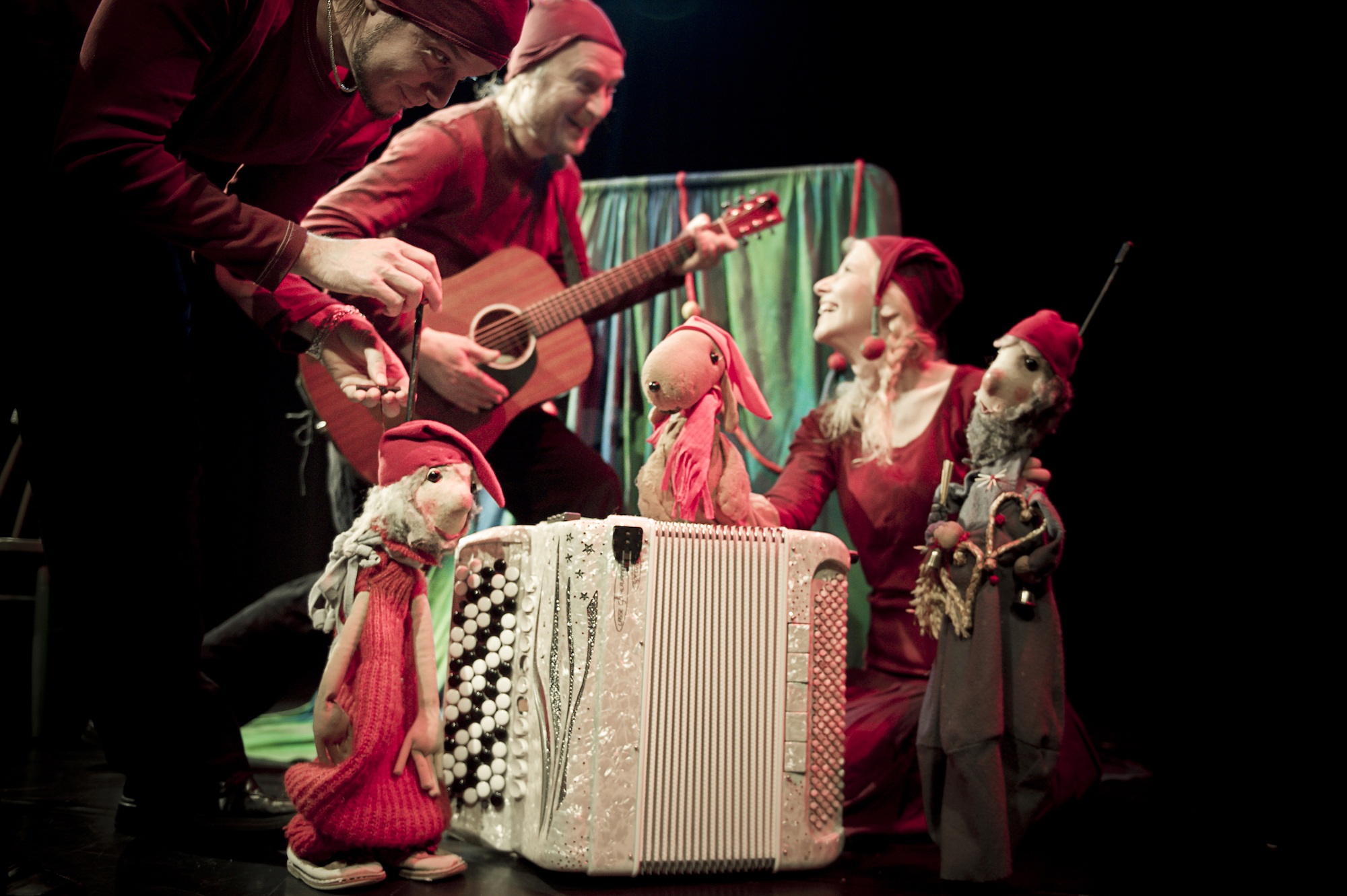 Haitari, jonka vieressä ja päällä Duppaduulix-nukke ja kaksi tonttua (nukketeatterinukkeja). Kolme nukeillanäyttelijää, joista yksi soittaa kitaraa, punaisissa vaatteissa ja tonttulakeissa. Nukketeatteri Sampo