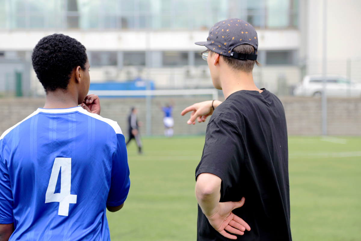 nuori jalkapalloilija keskustelee nuoriso-ohjaajan kanssa
