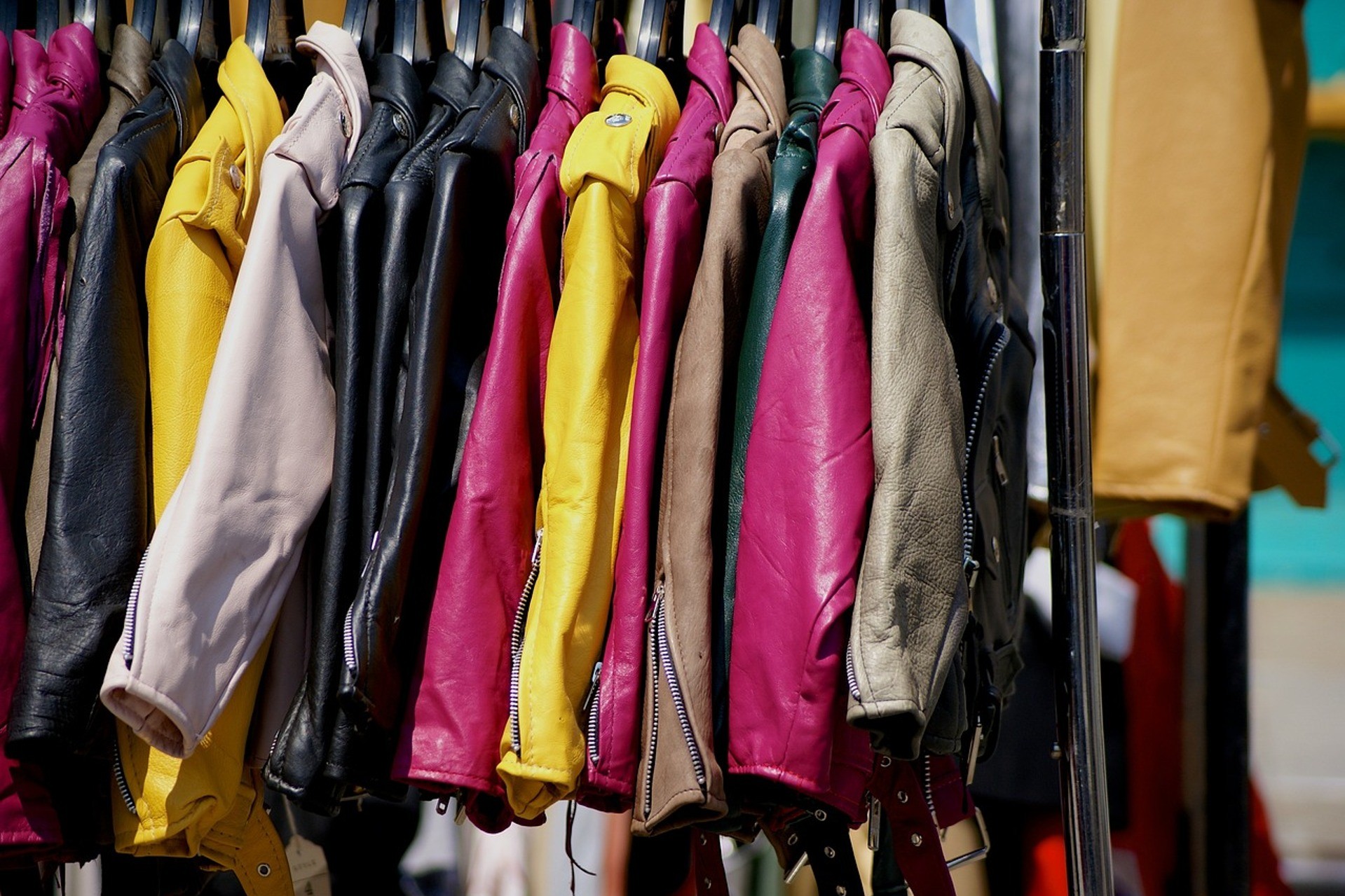 Eri värisiä takkeja roikkumassa vaaterekillä.