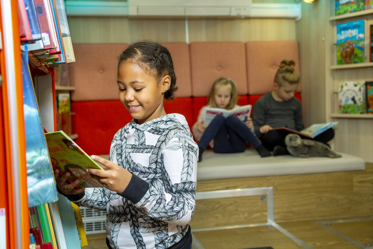 Lapsia kirjastossa lukemassa kirjoja