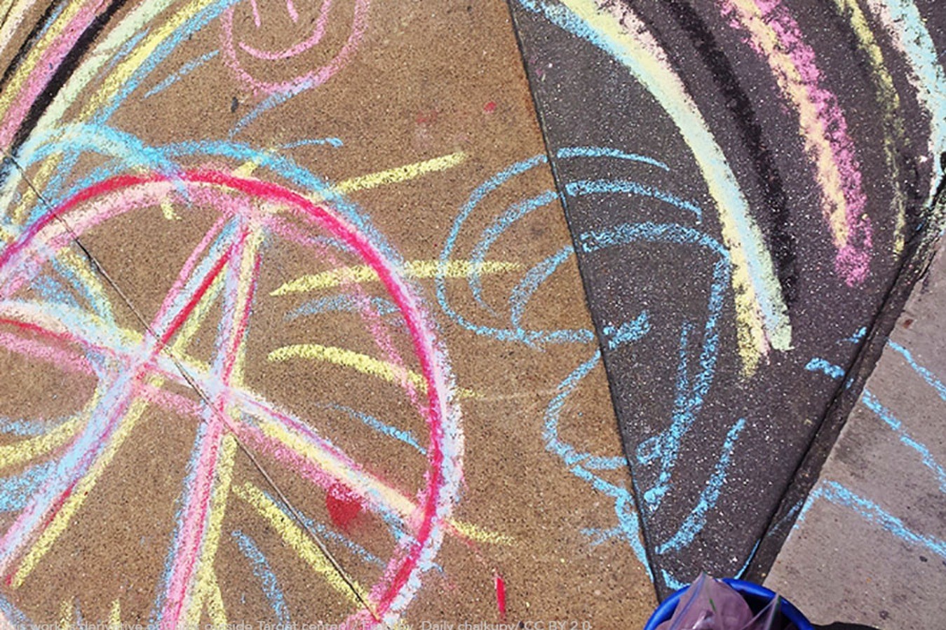 Värikäs lasten piirroksia täynnä oleva kuva asfaltista