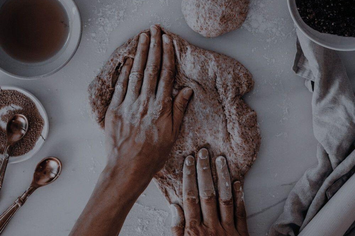 Kädet leipomassa taikinaa