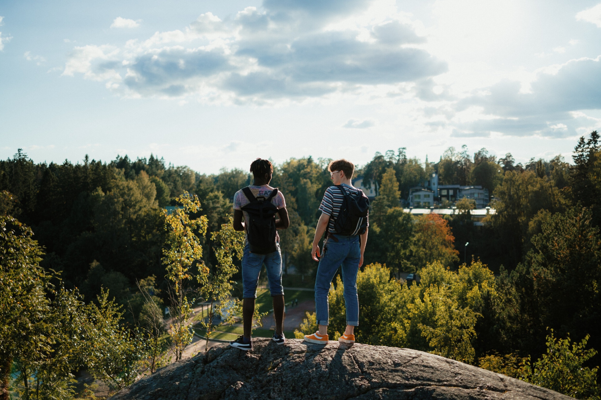 Kaksi nuorta miestä seisoo kalliolla